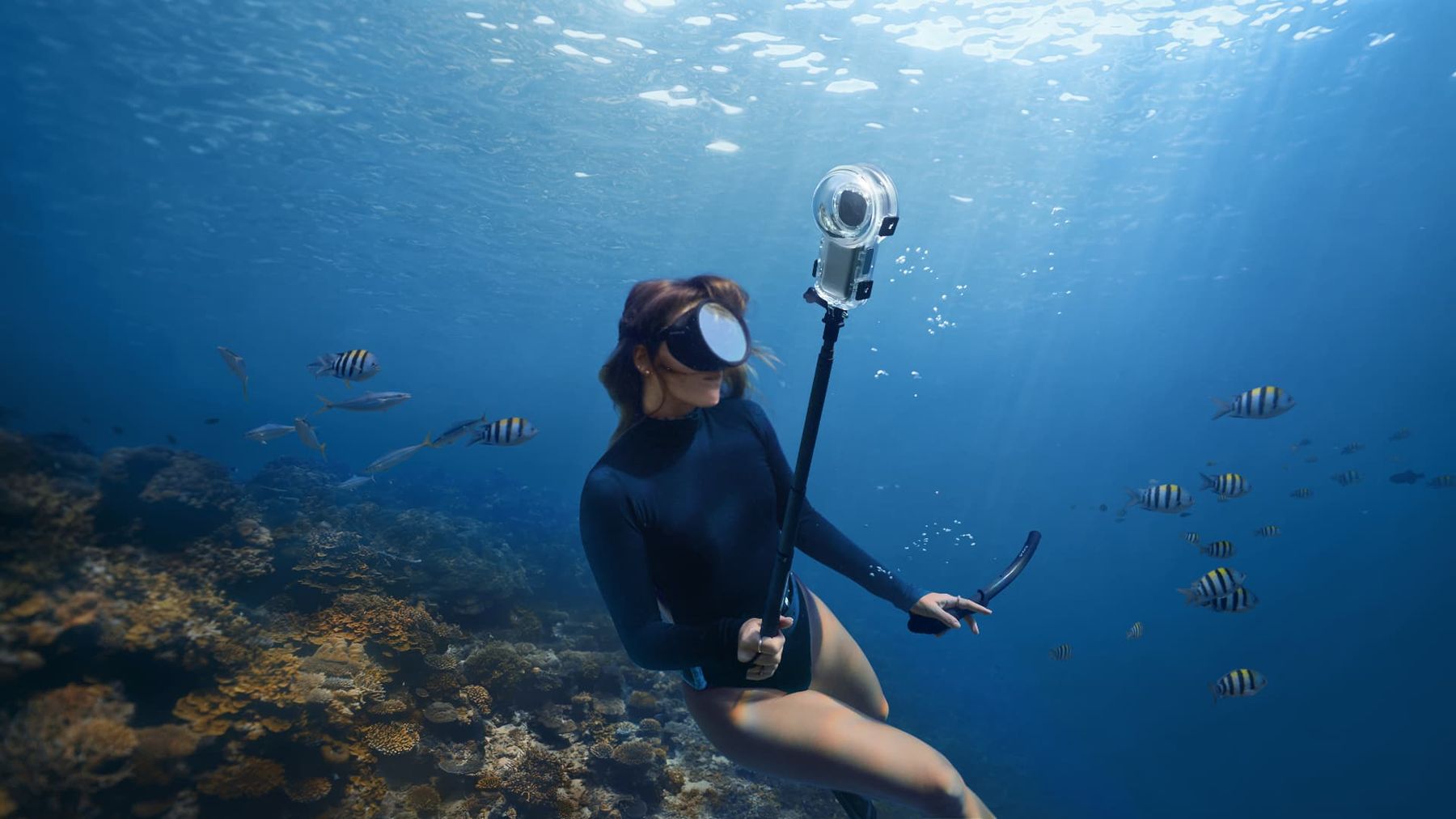 Freediver filming a reef with the X5 in a dive case